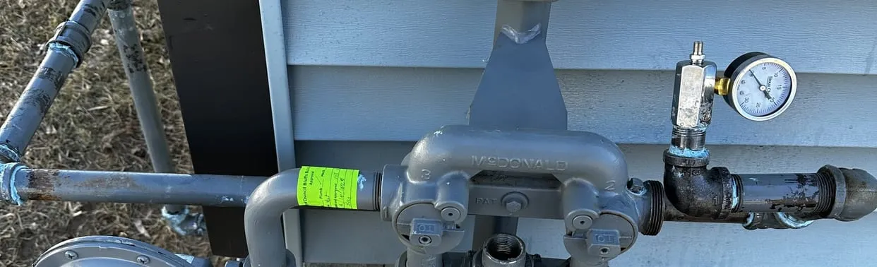 Gas meter, regulator and gas piping on the side of a house