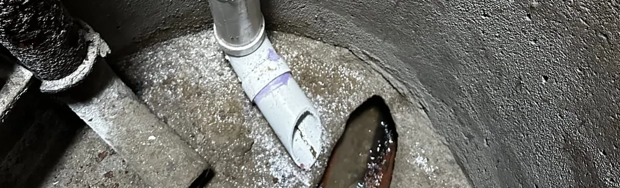 Sump pump discharge pipe in a concrete basement sump pit
