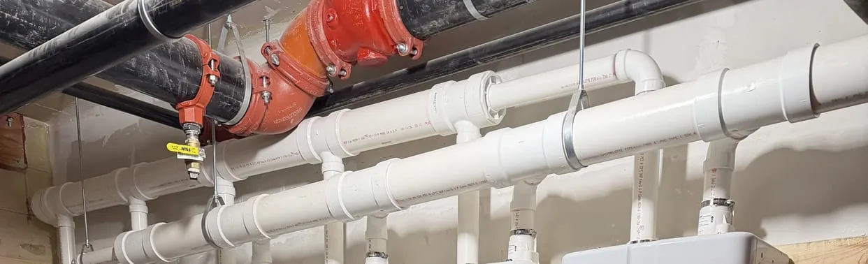 White PVC vent and water lines for a bank of tankless water heaters